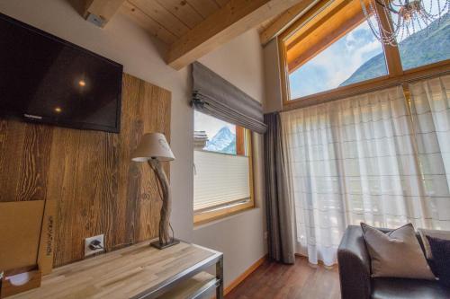 a living room filled with furniture and a window at Alpenlodge in Zermatt
