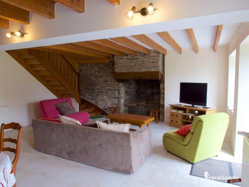 ein Wohnzimmer mit einem Sofa, Stühlen und einem TV in der Unterkunft Gite Lancelot du Val in Campénéac