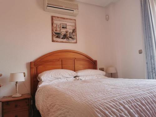 オリフエラ・コスタにあるCasa Marisaの大きなベッドと壁の絵が備わるベッドルーム1室が備わります。