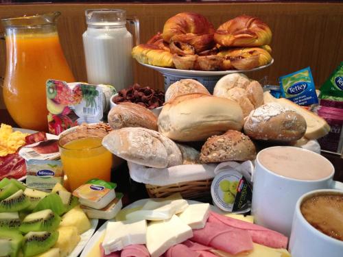 a table with a bunch of different types of breakfast foods at Park Hotel Porto Aeroporto in Maia