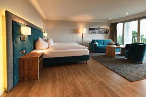 バーデン・バーデンにあるホテル レーベンホフのベッドとリビングルームが備わるホテルルームです。