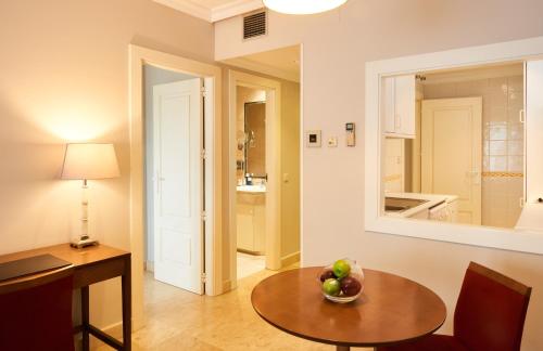 una habitación con una mesa con un bol de fruta en ella en Suites Barrio de Salamanca, en Madrid