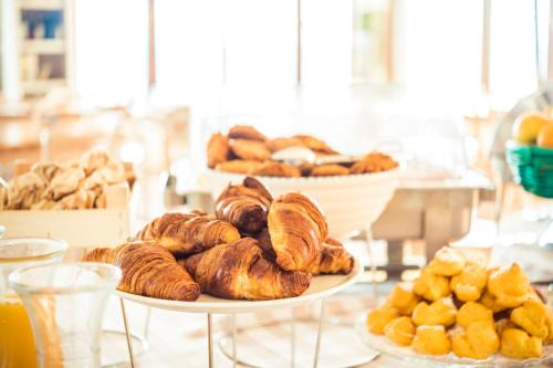 een tafel met twee schalen gebak en ander brood bij Club del Sole Desenzano Boutique Resort in Desenzano del Garda