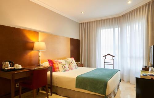Un pat sau paturi într-o cameră la Suites Barrio de Salamanca