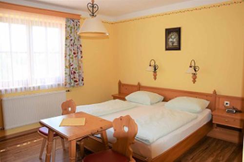 a bedroom with a bed and a table and a window at Gasthof Pichler in Grimmenstein