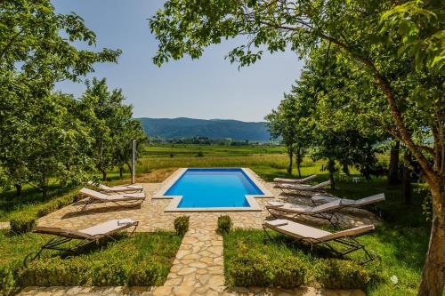 una piscina en un patio con tumbonas en Beautiful cottage with heated pool for 22 ppl, en Plaški