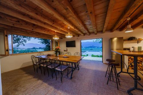 comedor con mesa, sillas y ventanas en Beautiful cottage with heated pool for 22 ppl, en Plaški