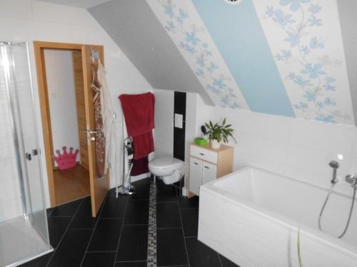 a bathroom with a white tub and a toilet at Gästehaus Querenhorst in Querenhorst