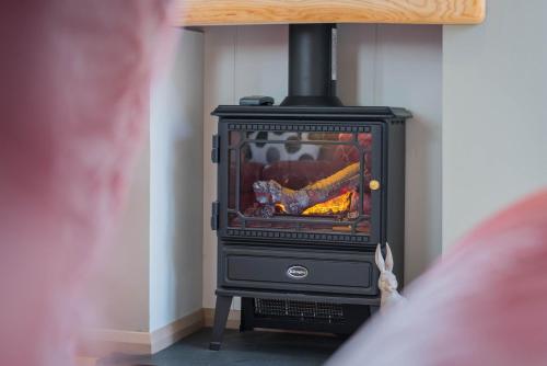 a man is standing in front of a stove at Dobby Lodge in Bassenthwaite