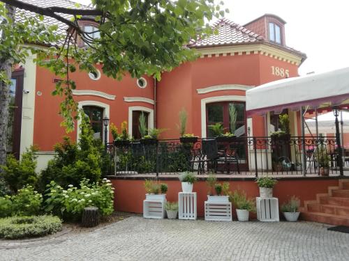 an orange house with plants in front of it at Dworek 1885 in Ostrzeszów
