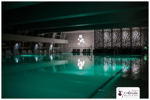 a swimming pool with chairs in a building at Bacolux Afrodita, Herculane in Băile Herculane