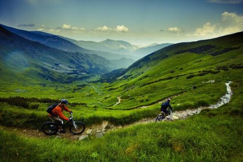 two people riding bikes on a grassy hill at Nina Liptov in Liptovský Ján
