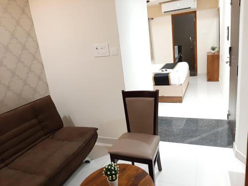 a living room with a couch and a table and a bed at Liza Regency in Chennai