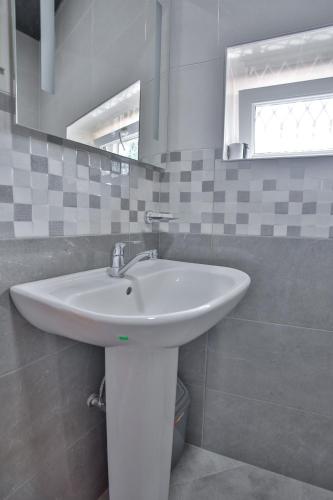a bathroom with a white sink and a mirror at Pospolita Guest House in Kutaisi