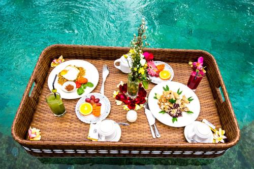 a tray of food on a table next to a pool at Puri Kobot in Ubud