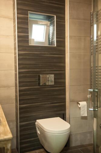 a bathroom with a toilet and a window on the wall at S.K.Suite in Drama