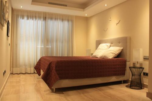 a bedroom with a bed with white pillows and a window at 104 - Apartment with private swimming pool in Estepona