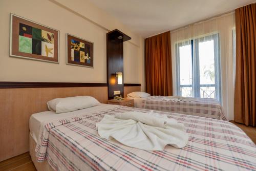 a hotel room with two beds with towels on them at Bezay Hotel in Fethiye
