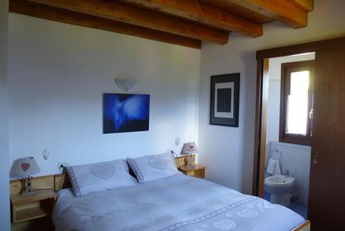 a bedroom with a white bed and a sink at Villa Genziana in Ovaro