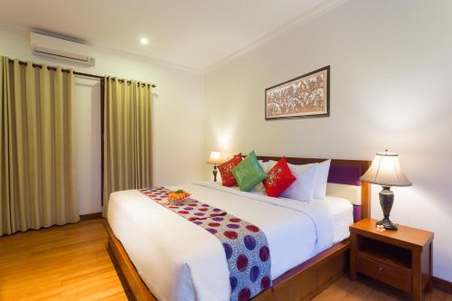 a bedroom with a large white bed and a window at Villa Sabasanti Gianyar in Keramas