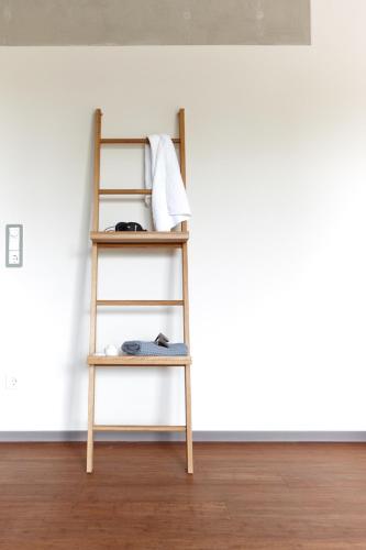 a ladder shelf in a room with a white wall at Just Eleven in Sankt Peter-Ording