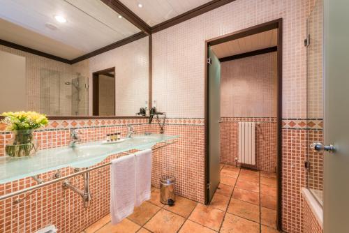 a bathroom with two sinks and a large mirror at Hospes Palacio de San Esteban, a Member of Design Hotels in Salamanca