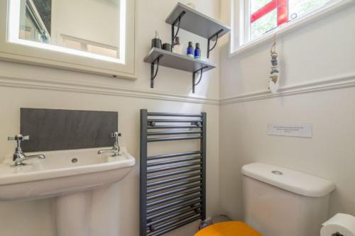 a bathroom with a sink and a toilet and a mirror at Thompson Hall Retreat in Thompson