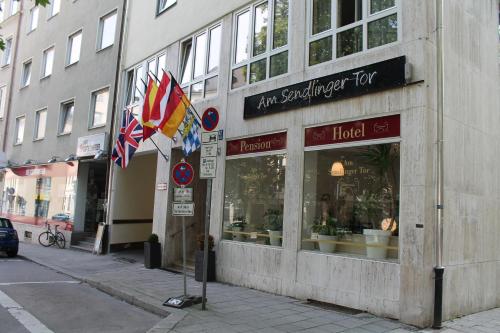 a store on a street with flags in front of it at Hotel Sendlinger Tor in Munich