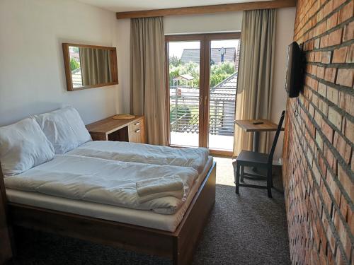 a bedroom with a bed and a brick wall at Baltik Park in Krynica Morska