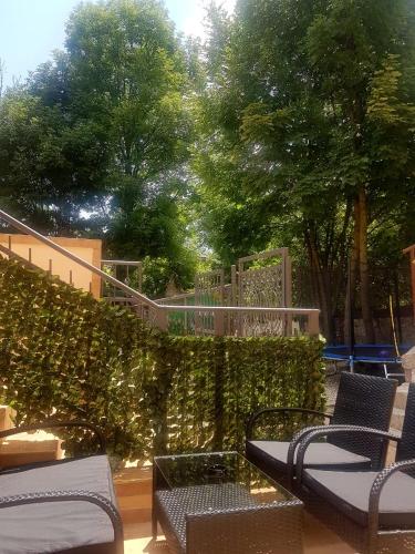 a patio with chairs and a fence and trees at Apartmani vuk in Cetinje