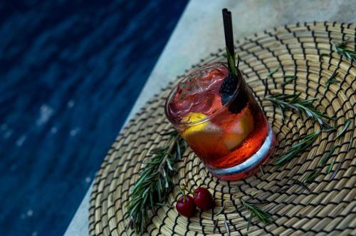 a drink sitting on a table next to a pool at Novotel Mohammedia in Mohammedia