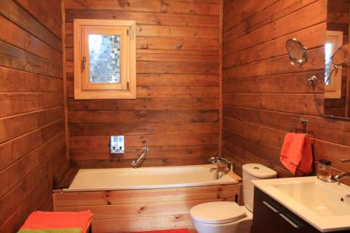 een badkamer met een bad, een toilet en een wastafel bij Casa de madera in A Coruña