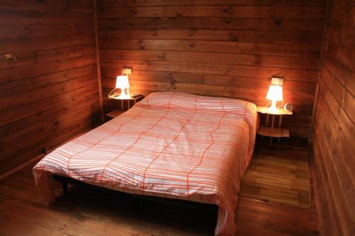 een slaapkamer met een bed met twee verlichting bij Casa de madera in A Coruña