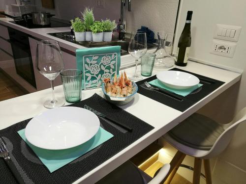 - un comptoir de cuisine avec 2 assiettes et des verres à vin dans l'établissement Casa Guidetta, à Castellabate