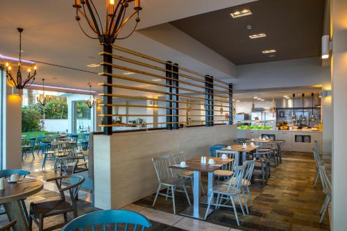 a restaurant with tables and chairs and a bar at Leonardo Cypria Bay in Paphos City