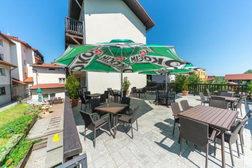 a patio with tables and chairs and an umbrella at Pensjonat Carmen in Szklarska Poręba