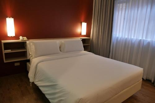 Ein Bett oder Betten in einem Zimmer der Unterkunft Circle Inn Hotel and Suites Bacolod