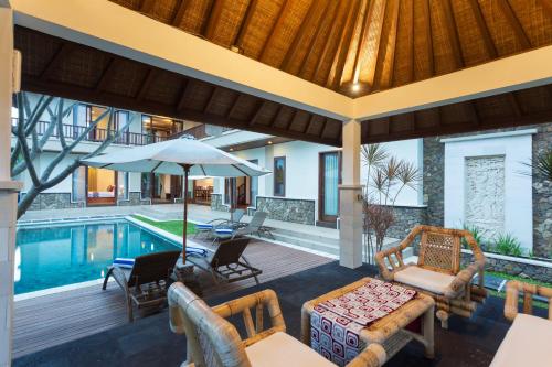 a house with a pool and a patio with furniture at Villa Sabasanti Gianyar in Keramas