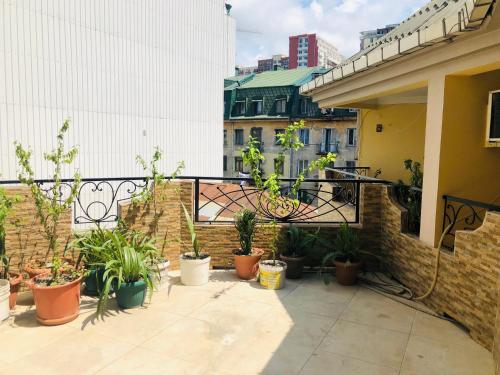 a balcony with potted plants on a building at hotel Pharnavaz in Batumi