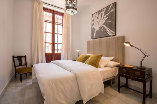 una camera con due letti, una lampada e una finestra di Indiana House Historical Center 5 pax a Siviglia