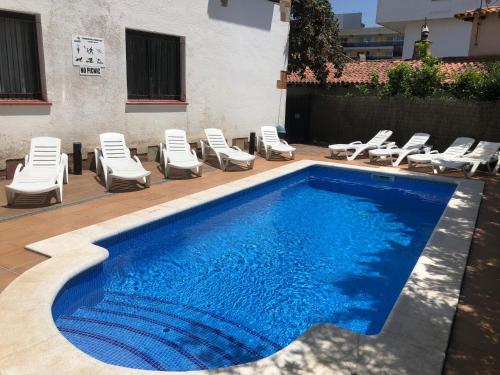 a swimming pool with chaise lounge chairs and a swimming pool at Apartamentos AR Caribe in Lloret de Mar