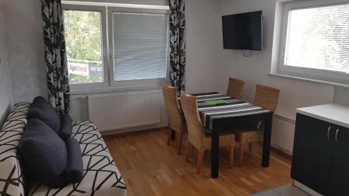 a dining room with a table and chairs and a television at Bled Apartments in Bled
