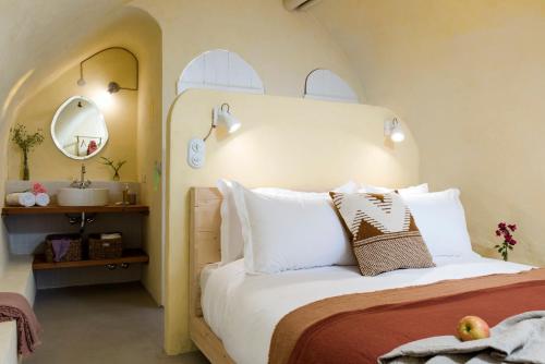 a bedroom with a bed with white pillows and a sink at La Maison des Sources in ‘Ayn Zḩaltā