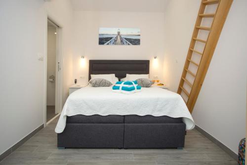 a bedroom with a large bed with a blue pillow on it at Central Old Town Rooms in Split