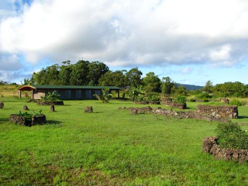 a large field with a building in the distance at Heva Eco Lodge in Hanga Roa