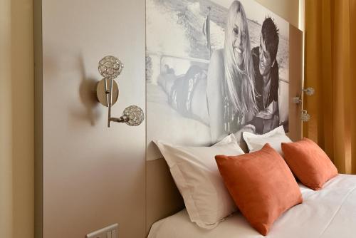 a bedroom with a bed with a picture on the wall at Hôtel Arles Plaza in Arles