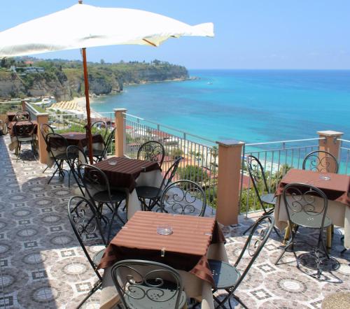 a row of tables and chairs with a view of the ocean at Hotel Terrazzo Sul Mare in Tropea