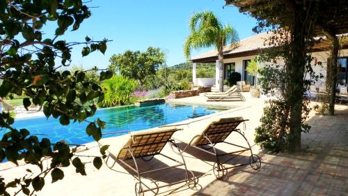two chairs sitting next to a swimming pool at Sharish - Monte Das Estevas in Estremoz