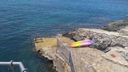a surfboard sitting on the edge of a cliff near the water at Your Home Montenegro in Dobra Voda