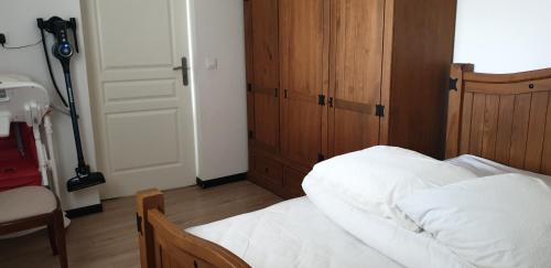 a bedroom with a bed with white sheets and a door at Les Petites Jardaises,6-8pers, tout à pied, plages, centre ville, port in Jard-sur-Mer